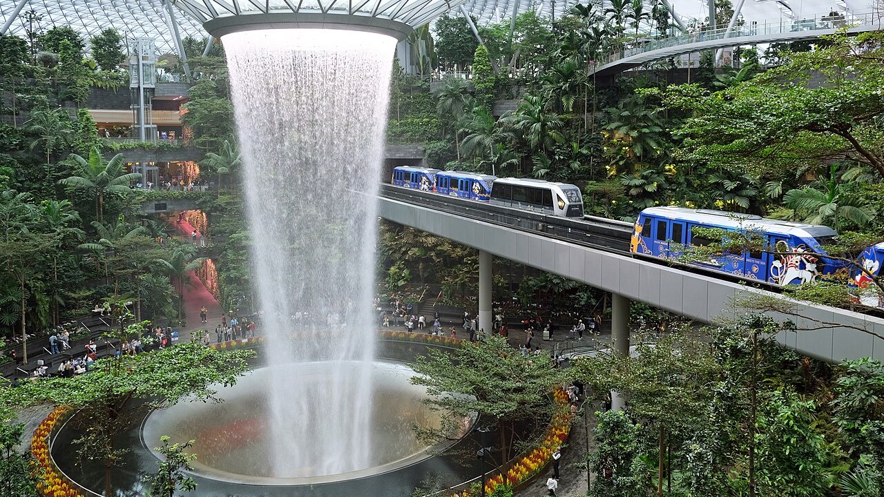 The Rain Vortex waterfall at Jewel Changi Airport, falling through a glass dome into terraced indoor gardens